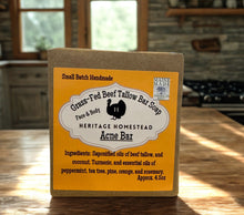 Load image into Gallery viewer, Bar of soap with a label on a wooden surface, set against a rustic background.