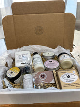 Load image into Gallery viewer, Box of natural skincare products with visible branding on a white background