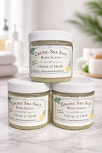Load image into Gallery viewer, Three jars of Celtic Sea Salt Body Scrub with Citrus &amp; Herb scent on a marble surface.
