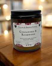 Load image into Gallery viewer, Tallow and Beeswax Candle jar labeled &#39;Coriander &amp; Rosewood&#39; on a wooden surface with blurred lights in the background
