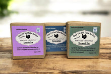 Load image into Gallery viewer, Three soap bars with packaging on a wooden surface. Handmade tallow soap bar made with grass-fed beef tallow, organic oils, and natural botanicals for gentle cleansing and deep hydration of dry and sensitive skin.
