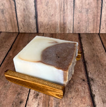 Load image into Gallery viewer, Naturally moisturizing tallow soap bar lavender cow colored with cocoa powder and lavender essential oils laying on a soap rest (Soap rest not included with Soap bar purchase)

