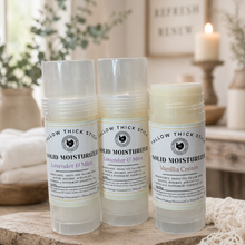 Load image into Gallery viewer, Natural tallow solid moisturizer sticks in lavender mint and vanilla cream scents on a rustic wood surface with cozy home background

