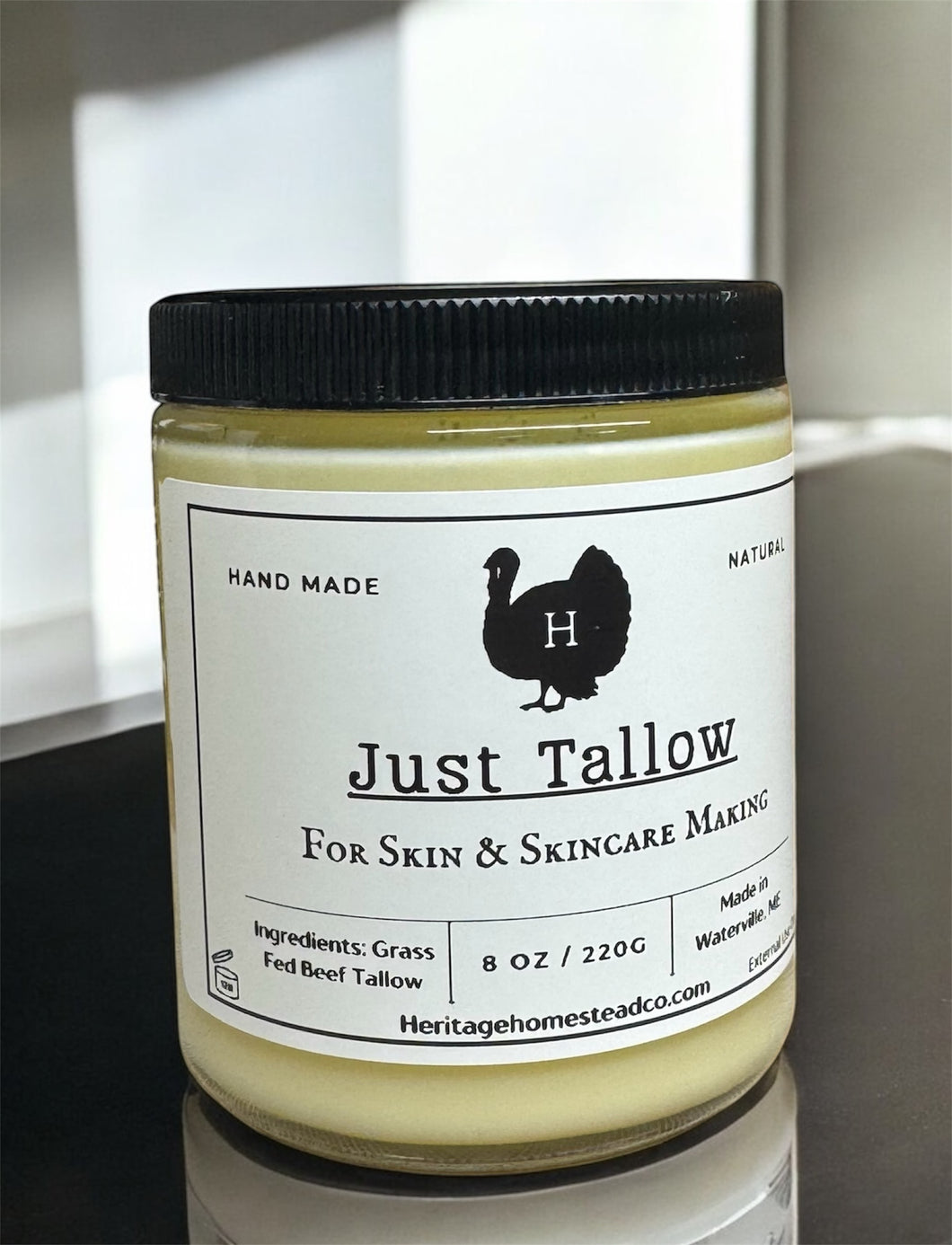 Jar of 'Just Tallow' for skin and skincare making 8 oz size glass jar on reflective surface