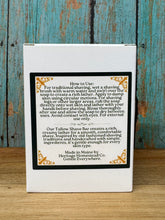 Load image into Gallery viewer, A white rectangular product box with a black central panel containing usage instructions and decorative gold corner flourishes, photographed from above on a distressed blue-green wooden surface next to a wood tabletop.
